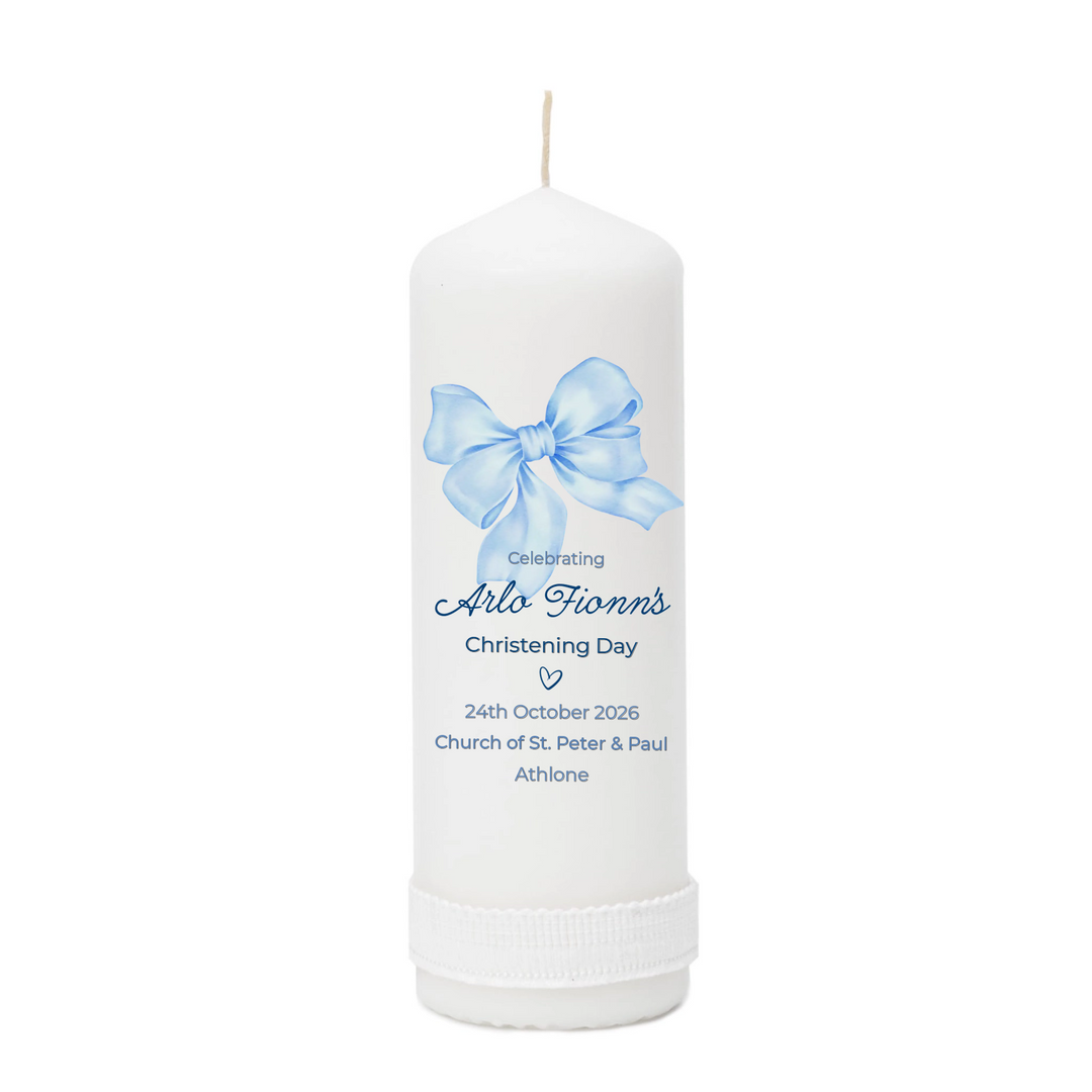 White candle with a blue bow and personalized text on a white background