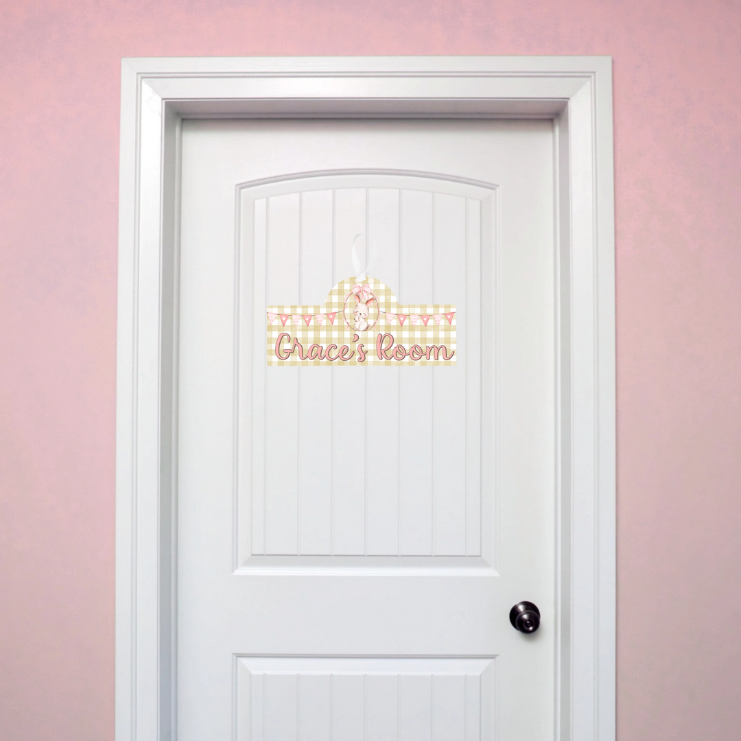 White door with decorative personalised name sign on a pink wall