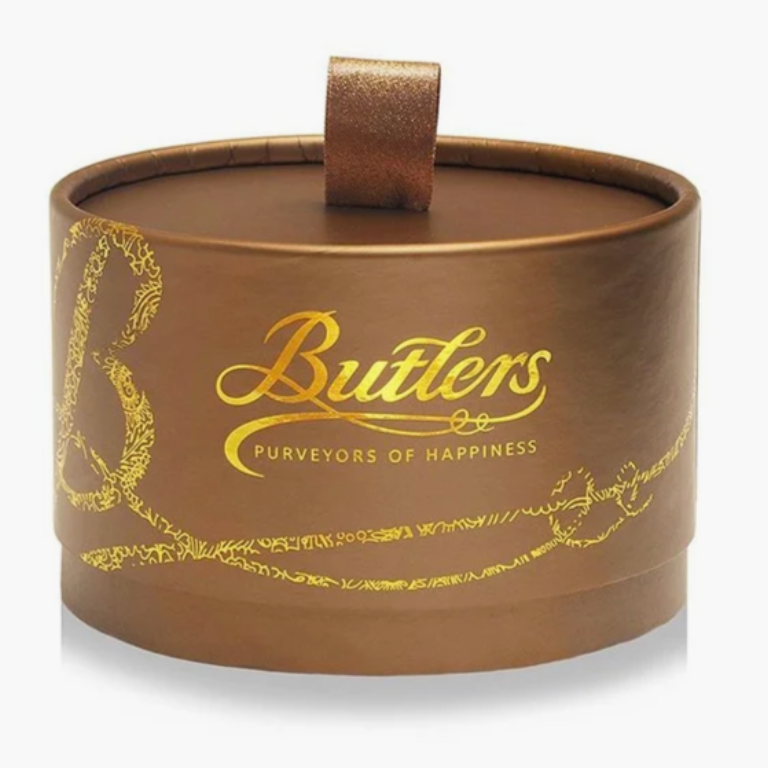 A cylindrical brown gift box with a matching lid and small top handle, printed with the Butlers logo in gold and decorative gold line art, on a light gray background.