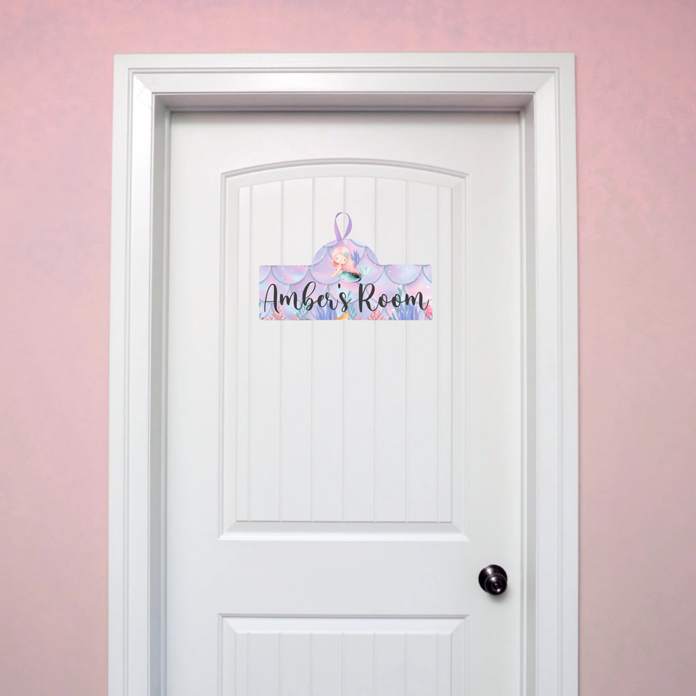 White door with a decorative personalised plaque on a pink wall