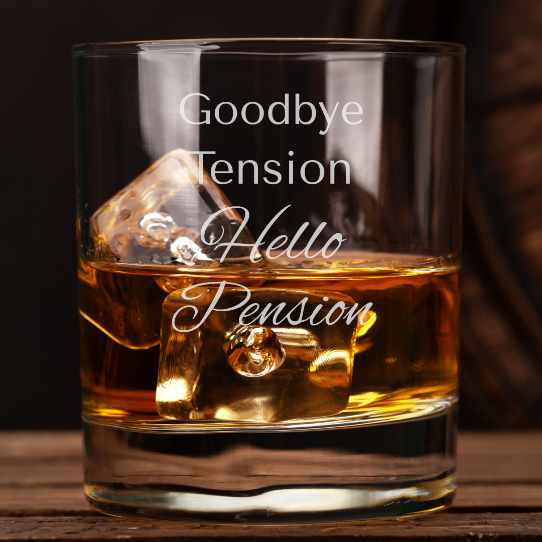 Glass of whiskey with ice cubes and engraved text on a wooden surface