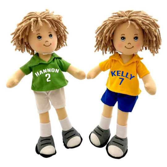 Two rag dolls, one in a green jersey with the name 'HANSON' and the number '2', and the other in a yellow jersey with the name 'KELLY' and the number '7'. Both dolls have brown hair and are wearing white shorts and gray shoes.