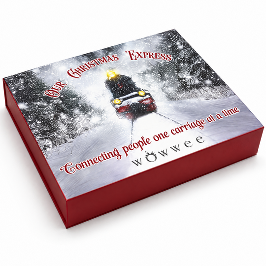 A red rectangular gift box with a winter holiday illustration on top, showing a snowmobile carrying a Christmas ornament in a snowy forest. Red script text on the lid reads 'Our Christmas Express' and 'Connecting people one carriage at a time', with the brand name 'wowwee' printed near the bottom.