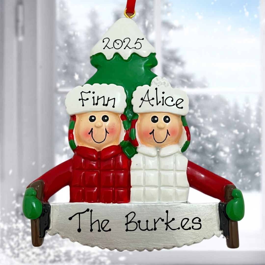Personalized Christmas ornament with two people named Finn and Alice, wearing winter hats and coats, with 'The Burkes' below them against a snowy background.