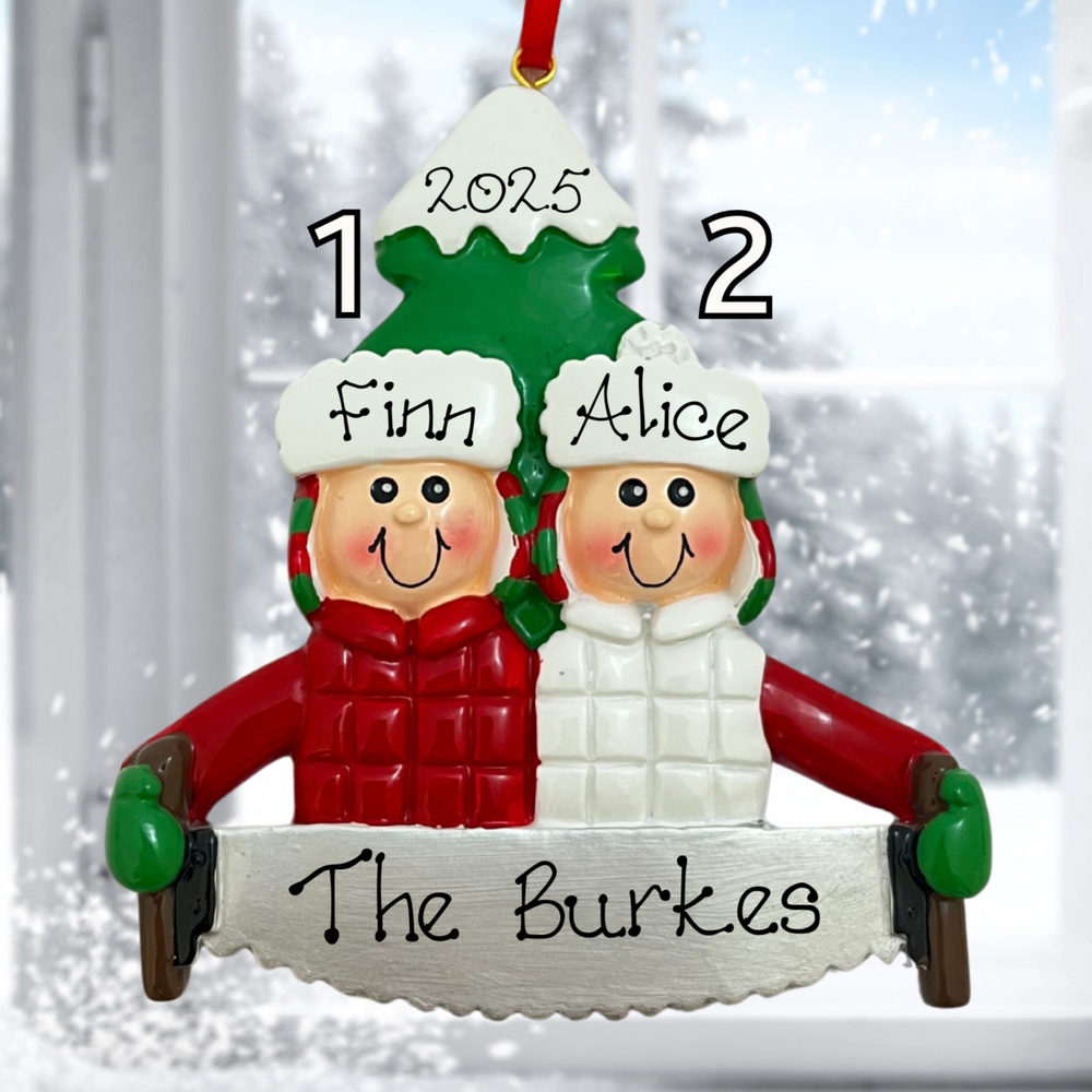 Personalized Christmas ornament with two children's names and a family name, set against a snowy window background.