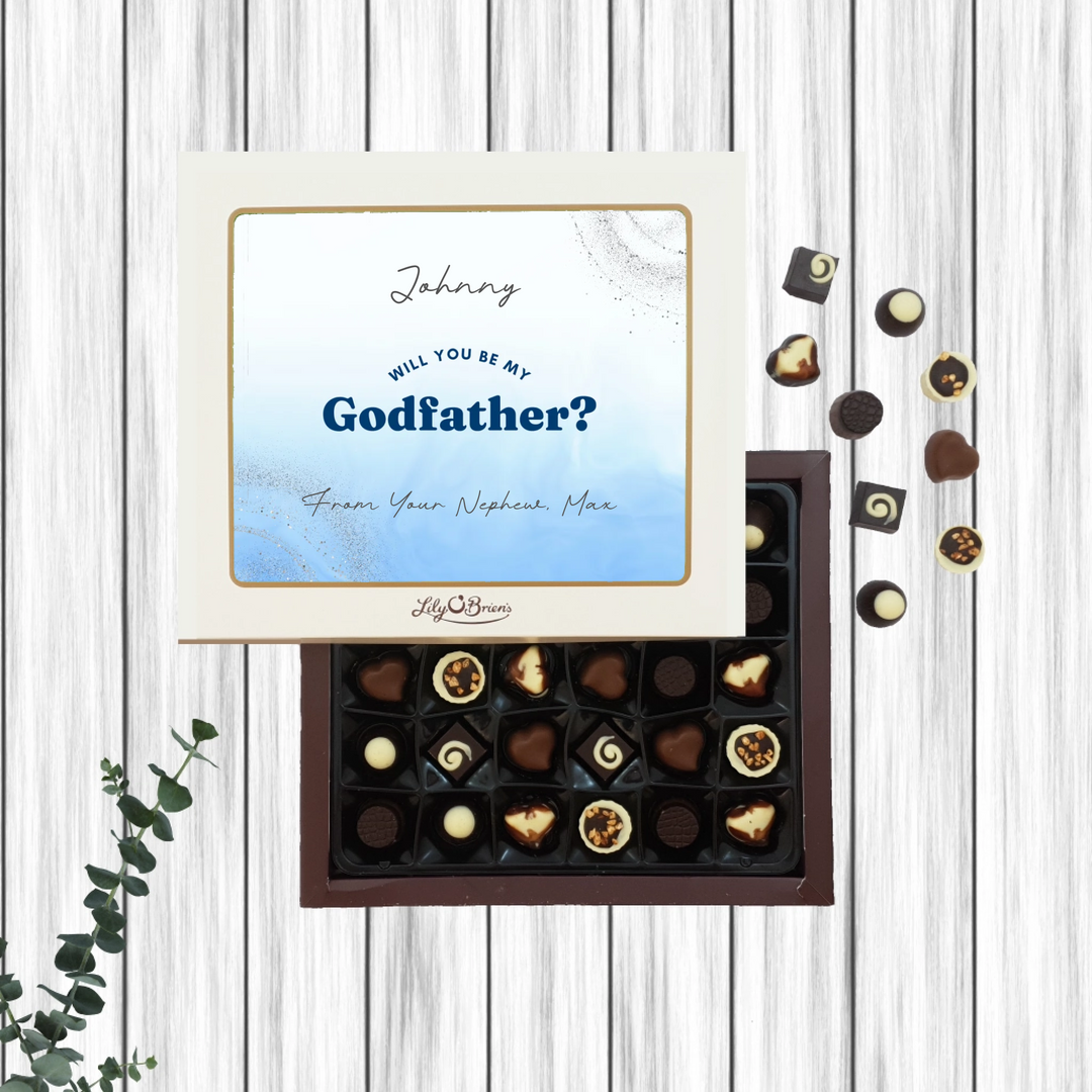 Chocolate box with 'Will you be my Godfather?' message on a wooden surface