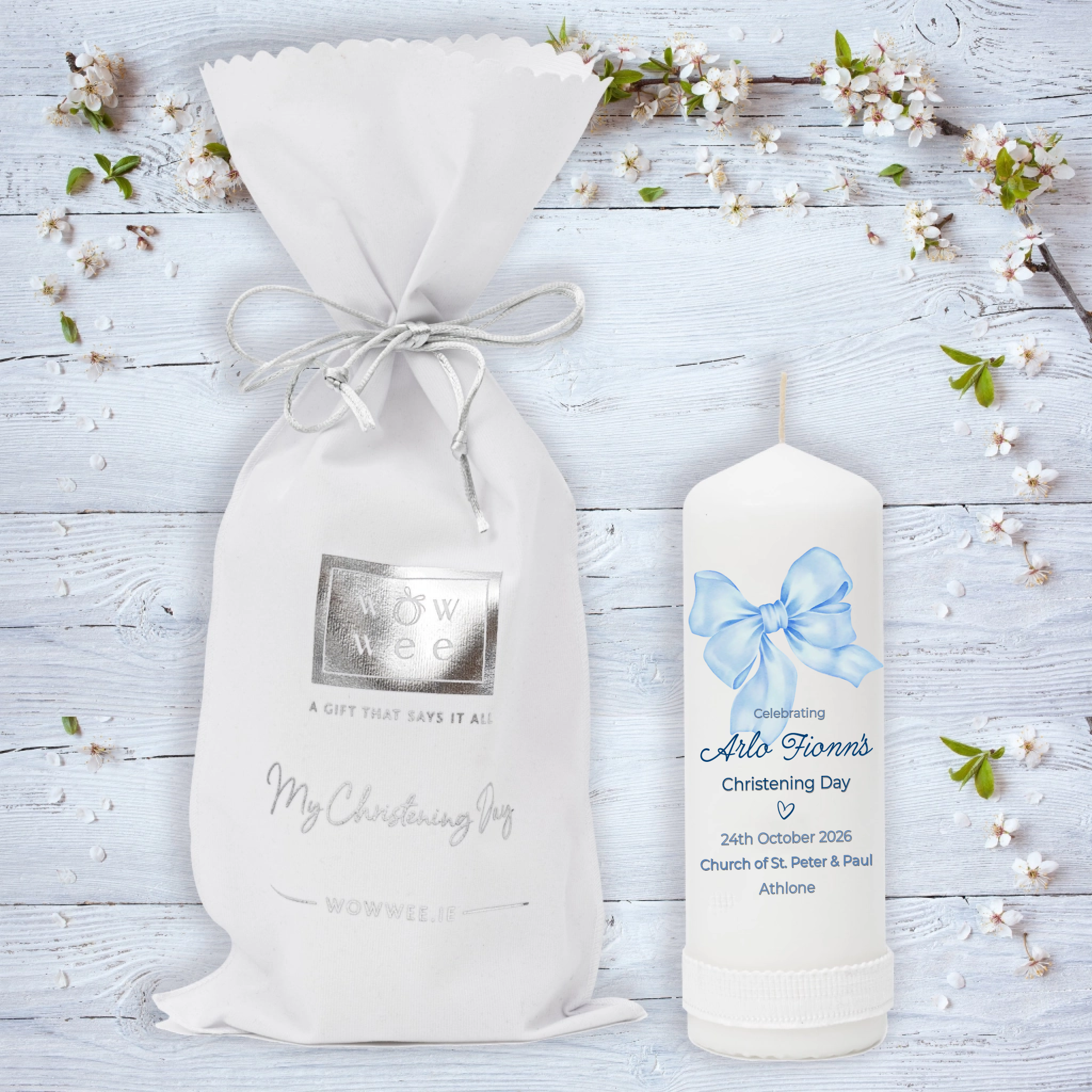 Personalized candle and gift bag on a wooden surface with floral decorations