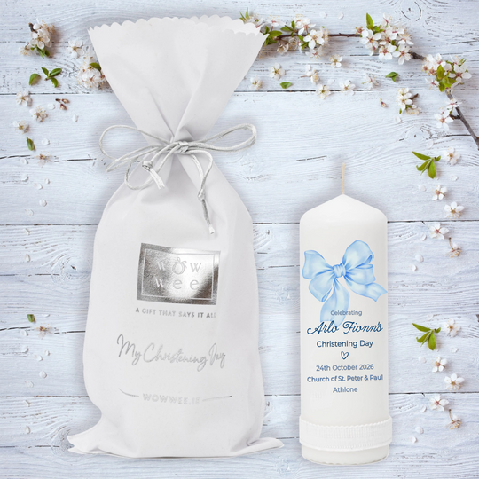 Personalized candle and gift bag on a wooden surface with floral decorations