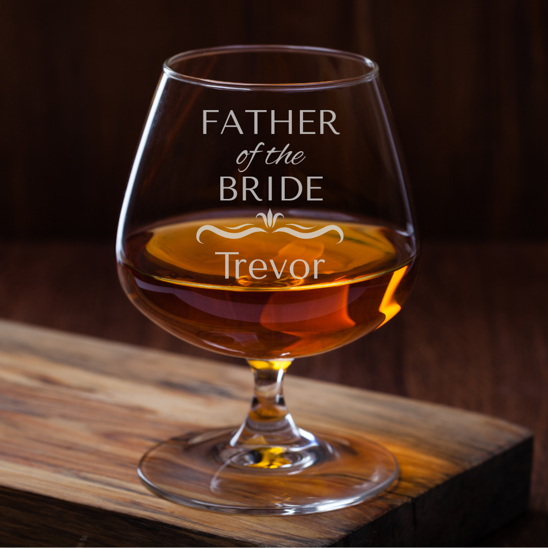 Personalized glass filled with amber liquid on a wooden surface