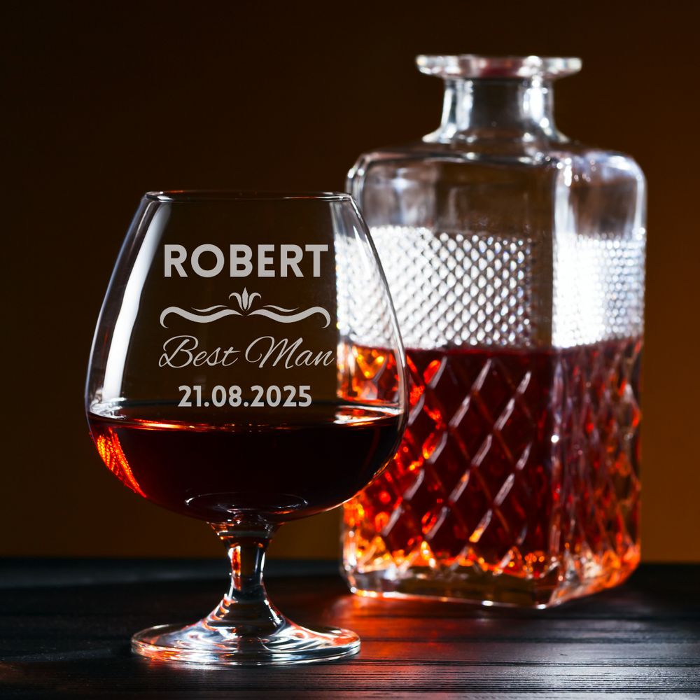 Personalized glass and decanter with brandy on a wooden surface