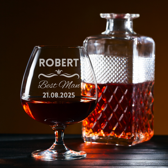 Personalized glass and decanter with brandy on a wooden surface