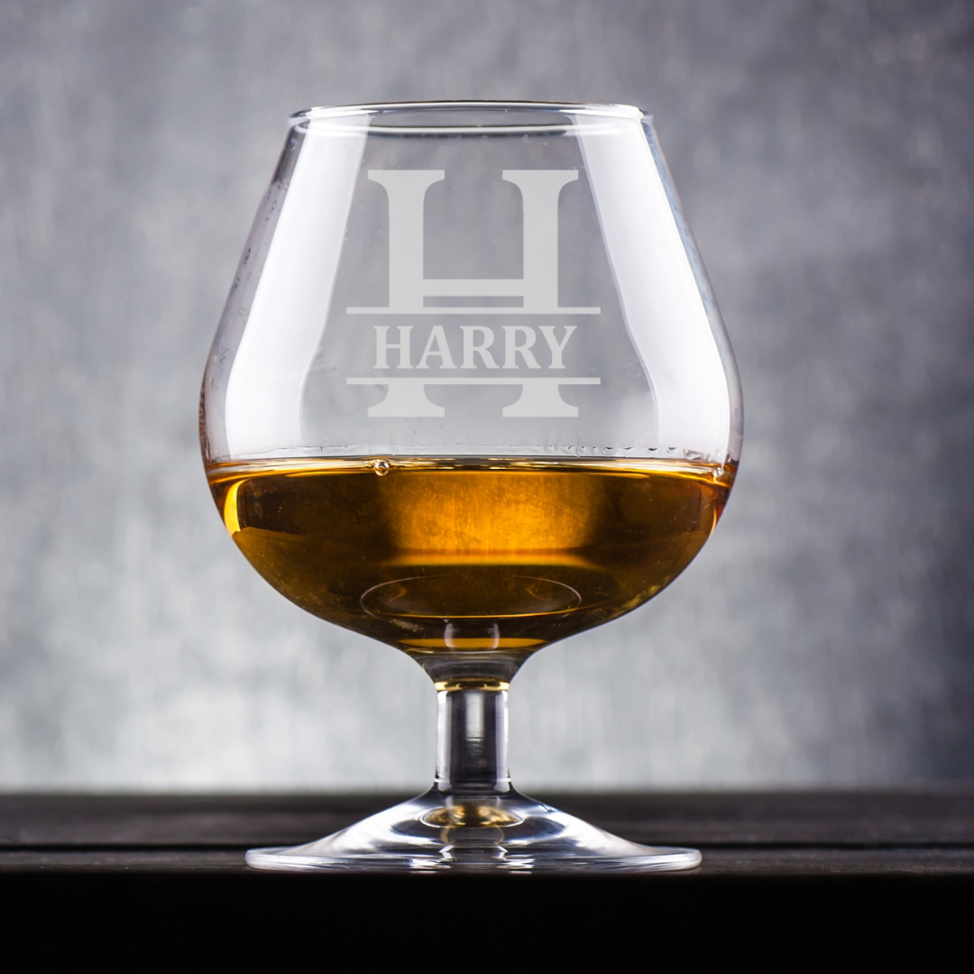 Brandy glass with 'HARRY' engraving on a gray background