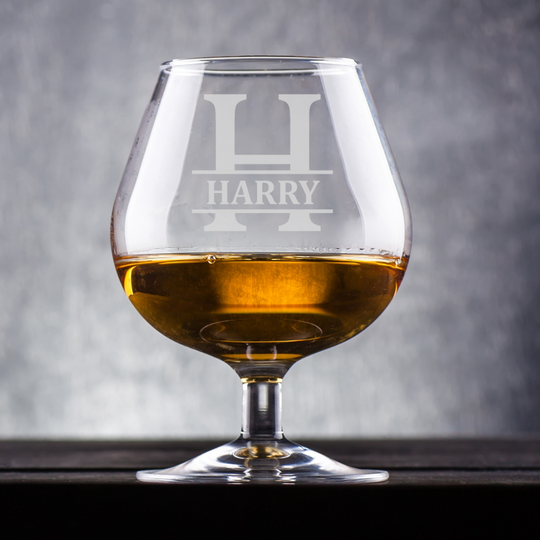 Brandy glass with 'HARRY' engraving on a gray background