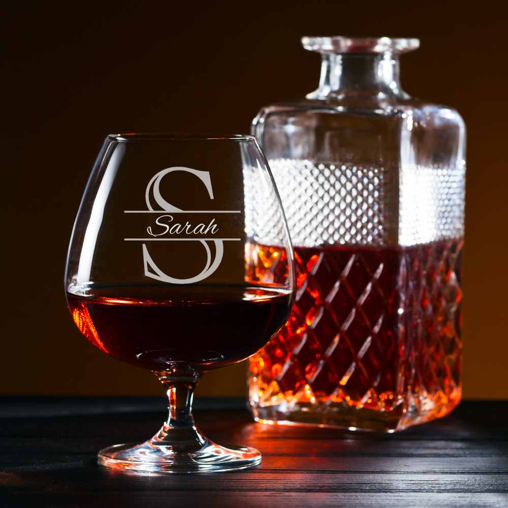 Brandy glass and decanter with 'Sarah' engraving on a dark background