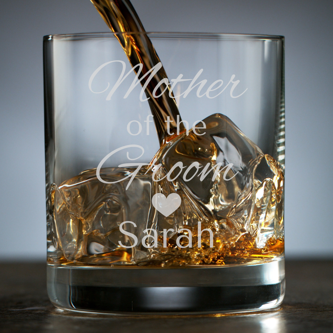 Glass with engraved text 'Mother of the Groom Sarah' being filled with whiskey.