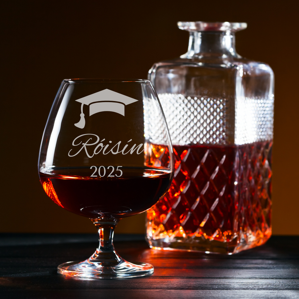 Glass decanter and glass with engraved design and 'Roisin 2025' text on a dark background