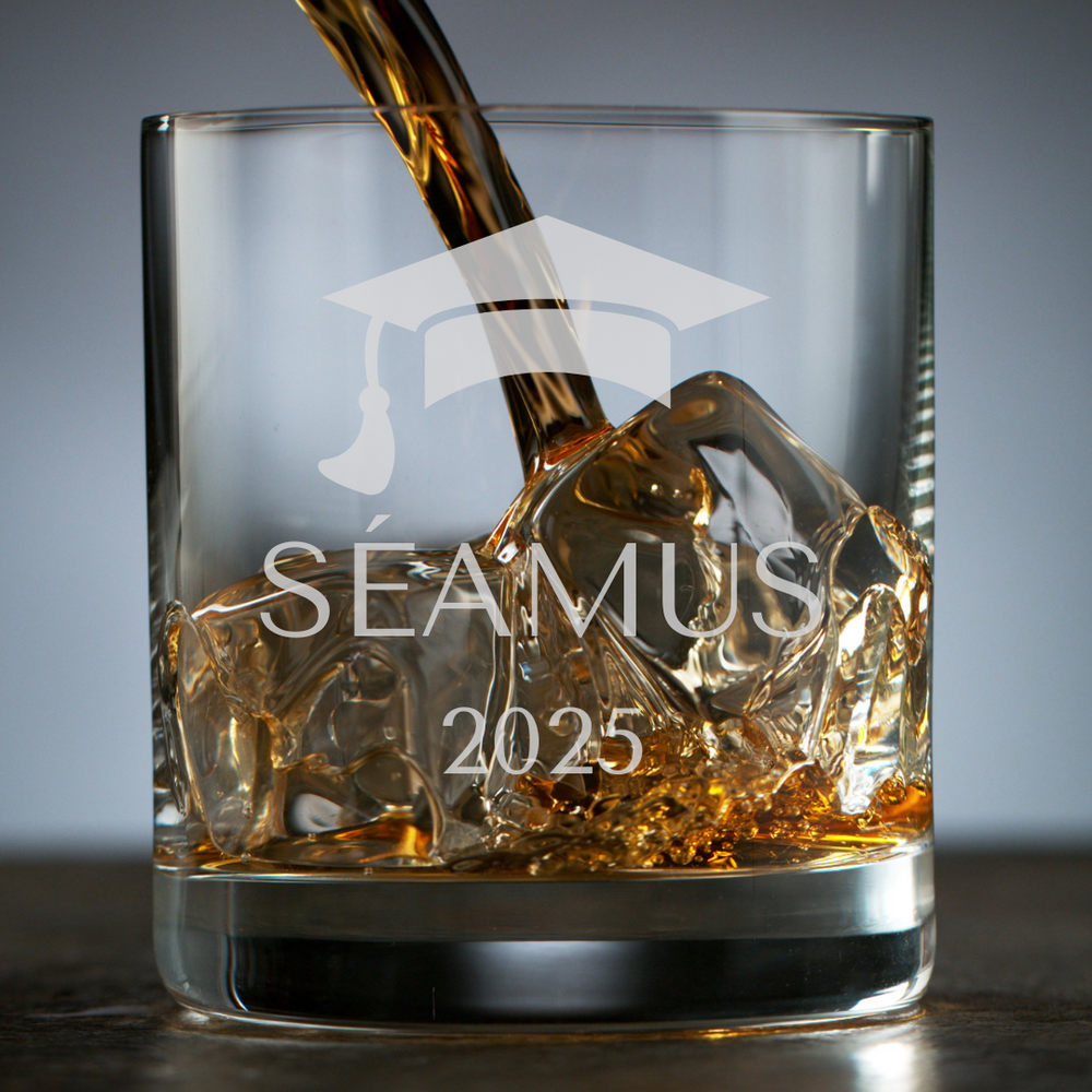 Glass with 'Séamus 2025' text and graduation cap design, filled with a golden liquid.