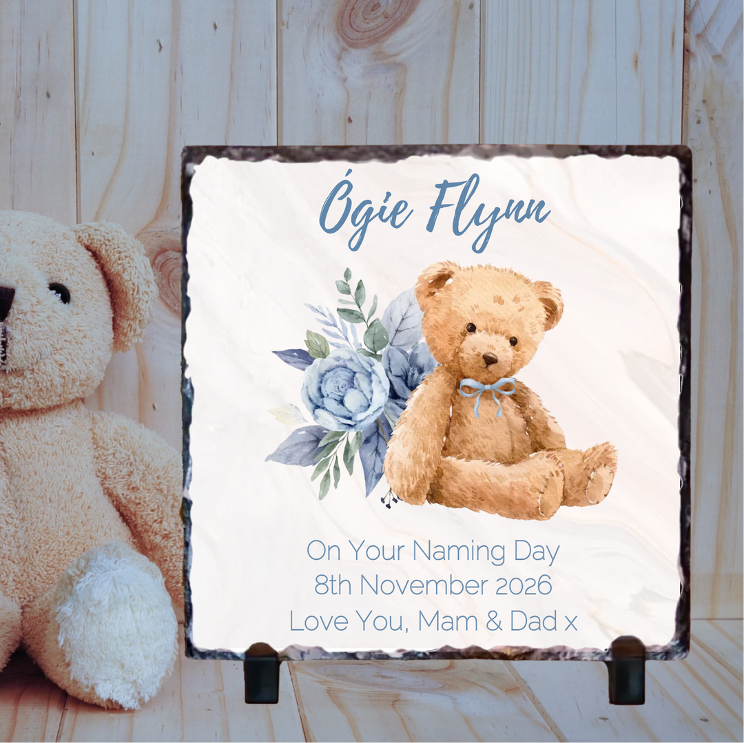 Personalized plaque with teddy bear and flowers for a naming day, featuring the name 'Ogie Flynn'.