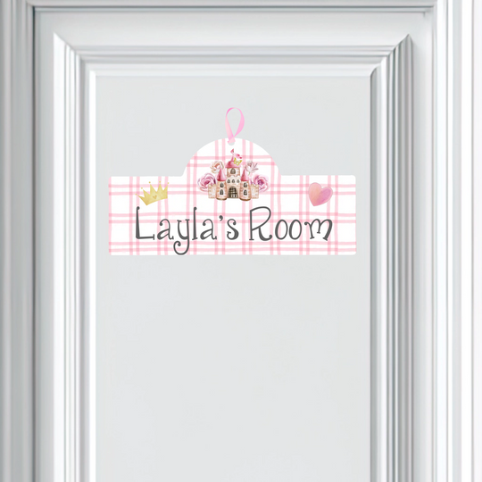Decorative sign with 'Layla's Room' text on a pink plaid background, framed in white.