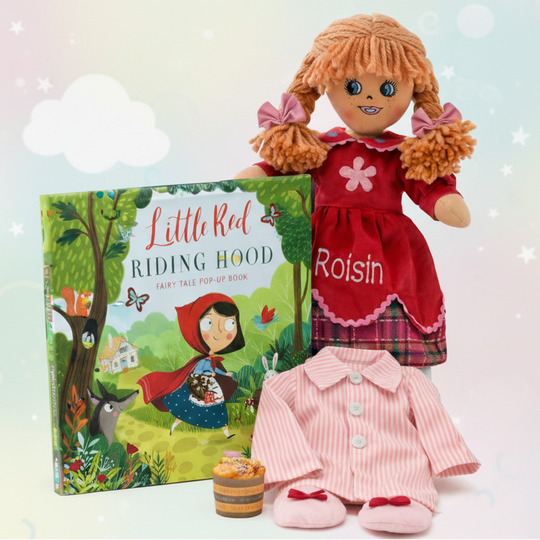Doll named Poppy in a red dress with a 'Little Red Riding Hood' book on a light background