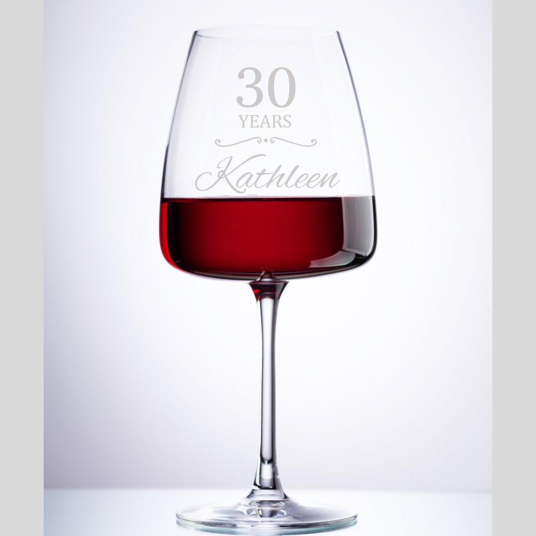 Wine glass with red wine and '30 Years Kathleen' engraving on a white background