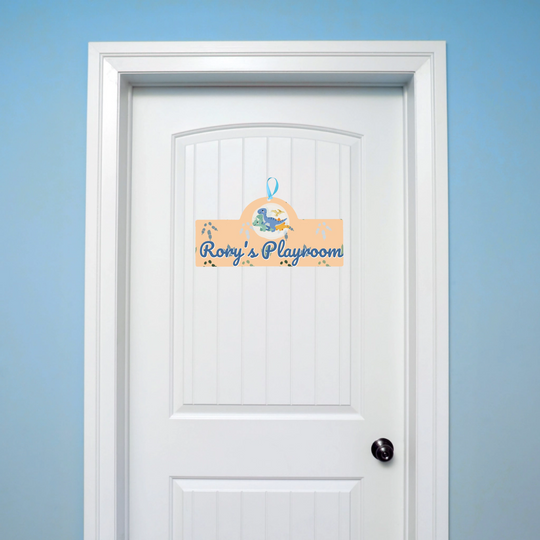 White door with a decorative sign reading 'Rory's Playroom' on a light blue background