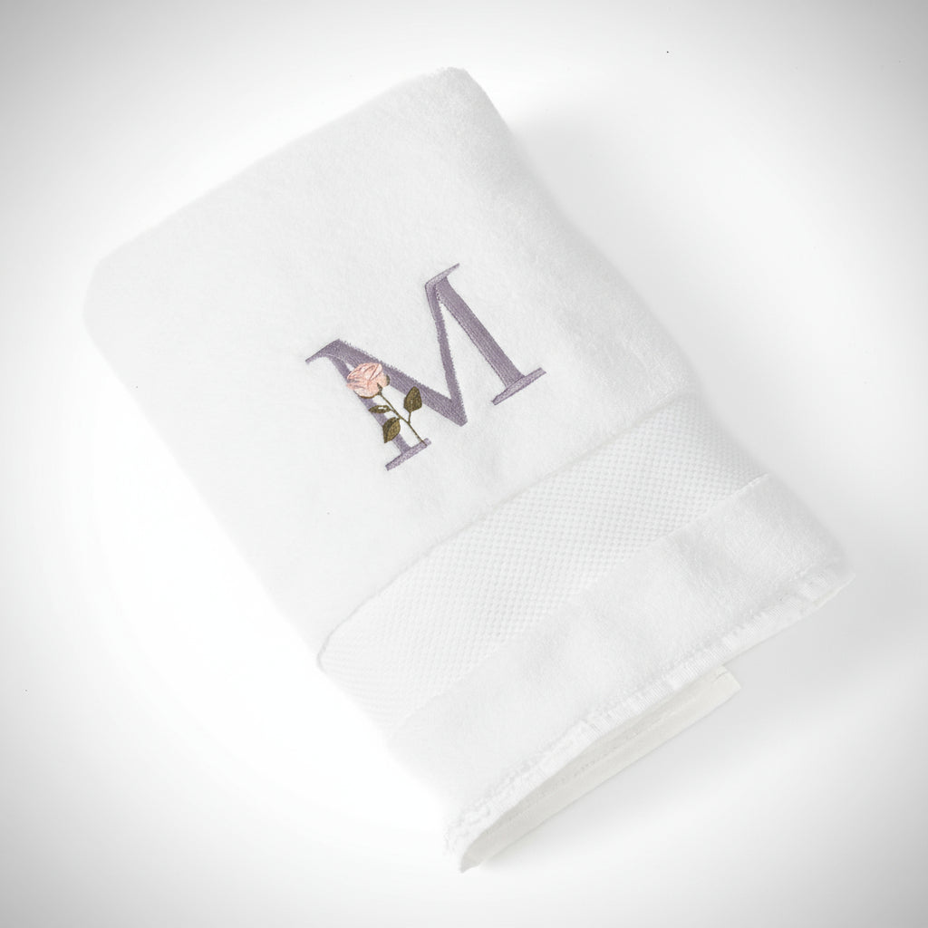 White bathtowel with a embroidered letter 'M' on a white background