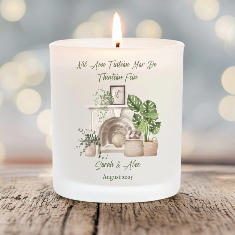 Personalised Candle with decorative design for new home and text on a wooden surface with blurred lights in the background